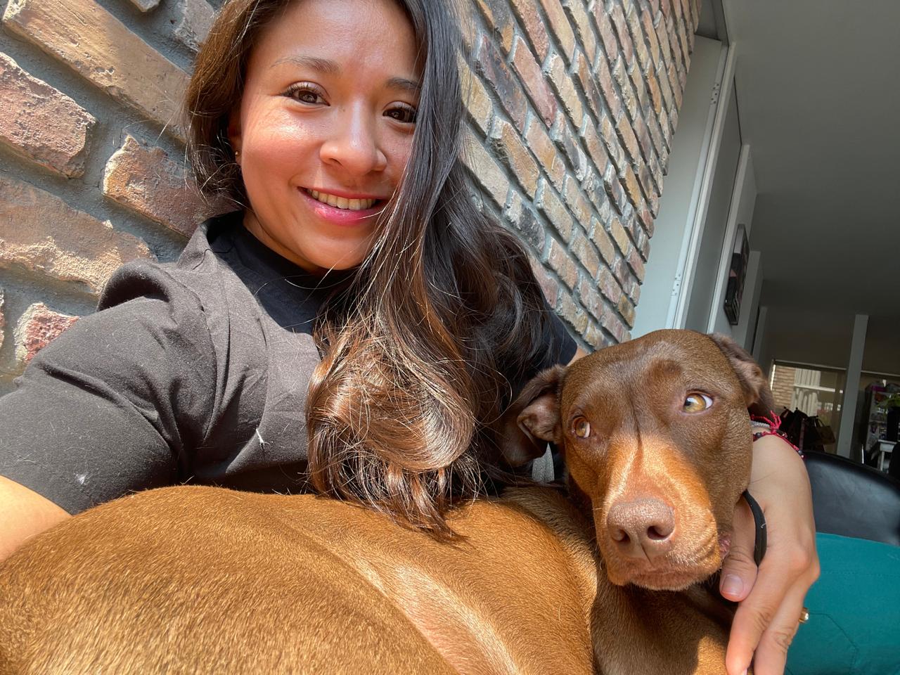 Meli abrazando a su perro, un momento de ternura y conexión.